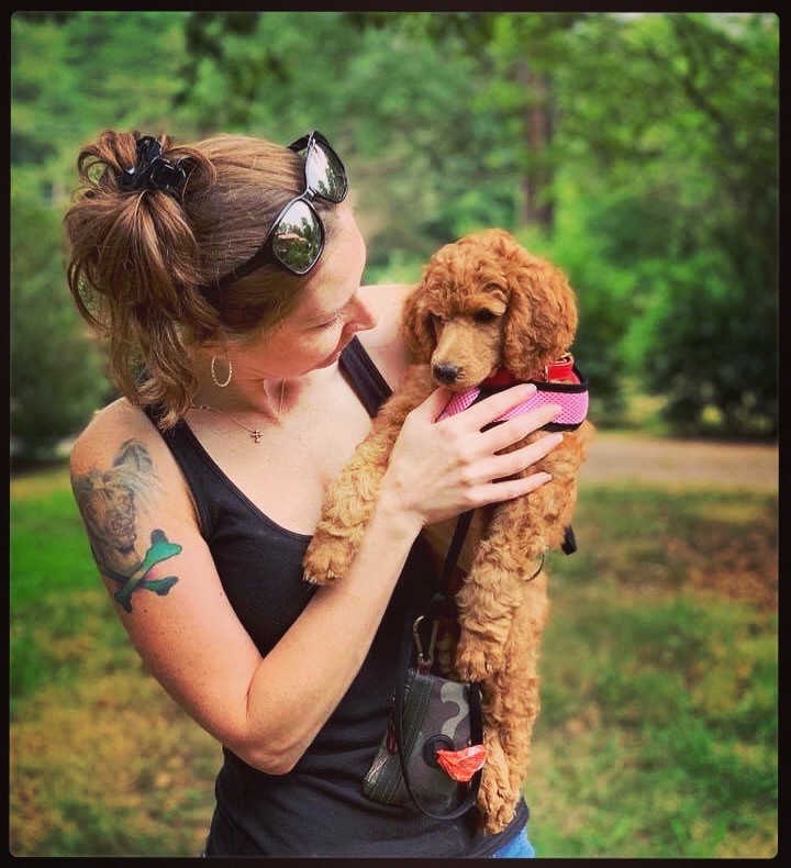 Woman with red poodle puppy outside